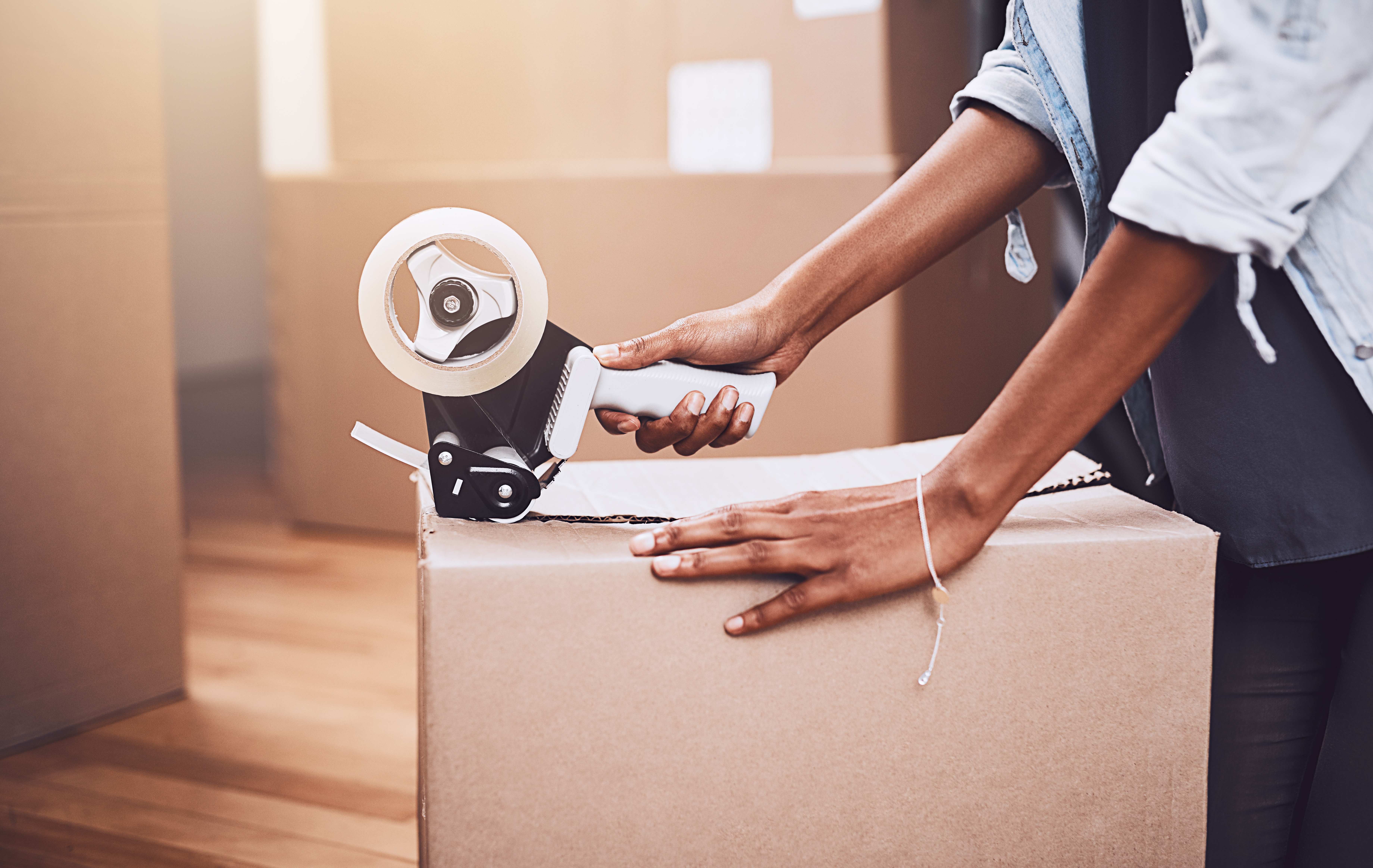 Woman with packing tape and boxes