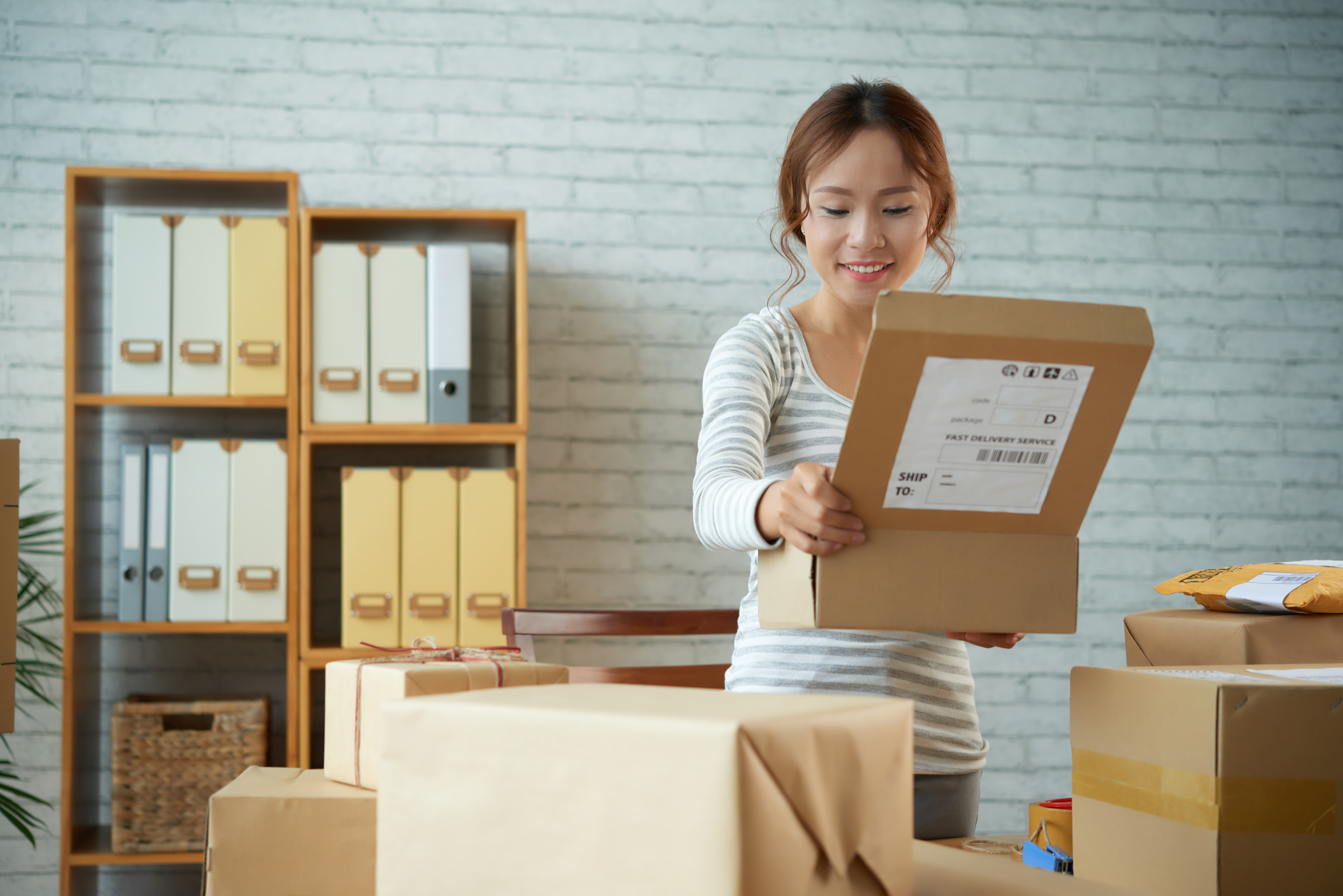 Woman opening parcel in office