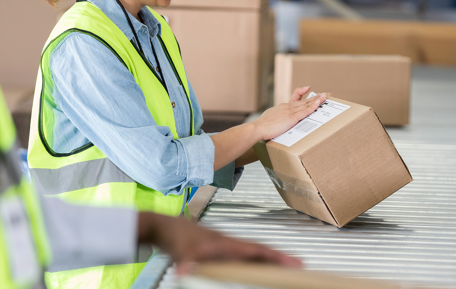 Warehouse Employee Placing Mailing Label On Box