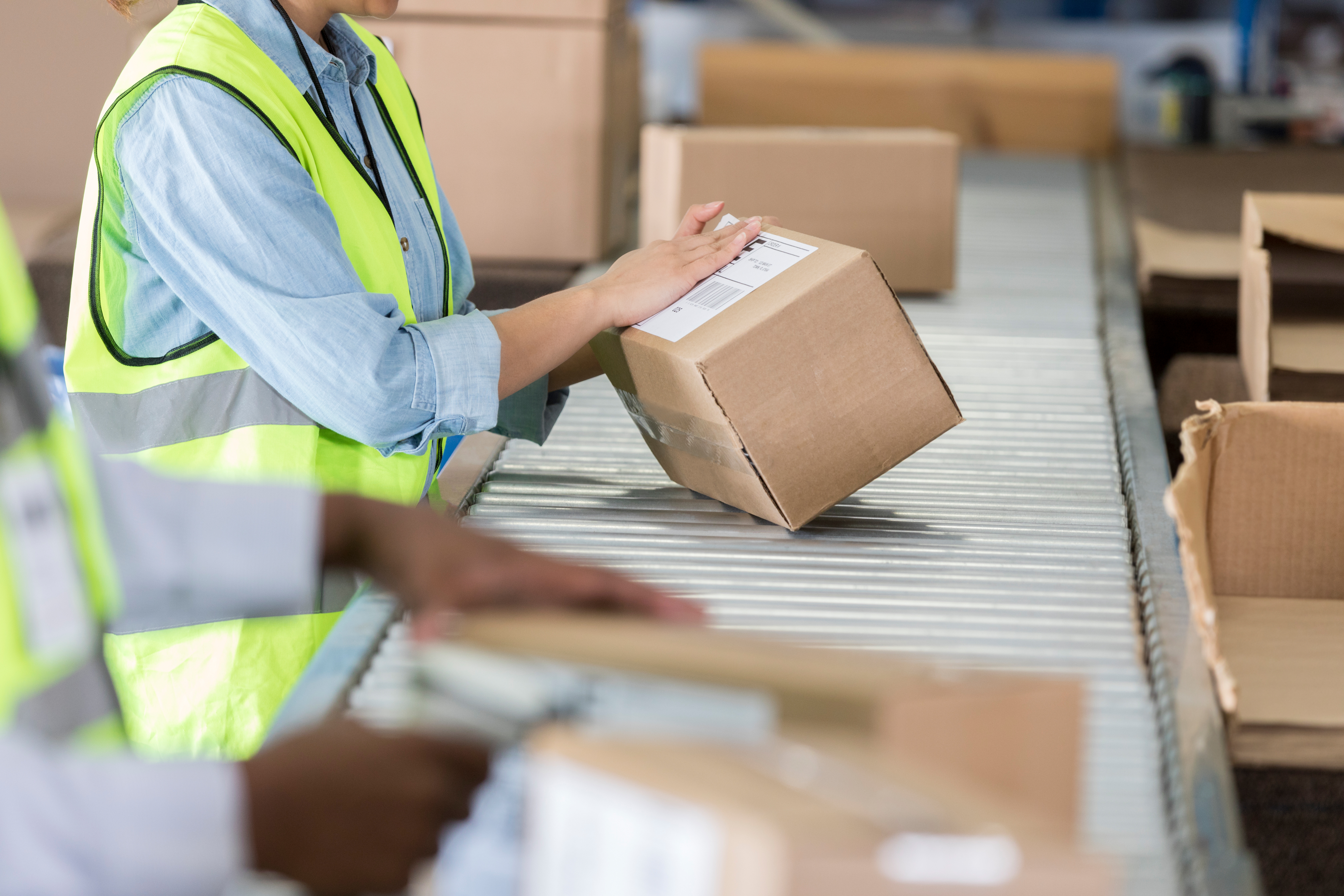 Warehouse employee placing mailing label on box